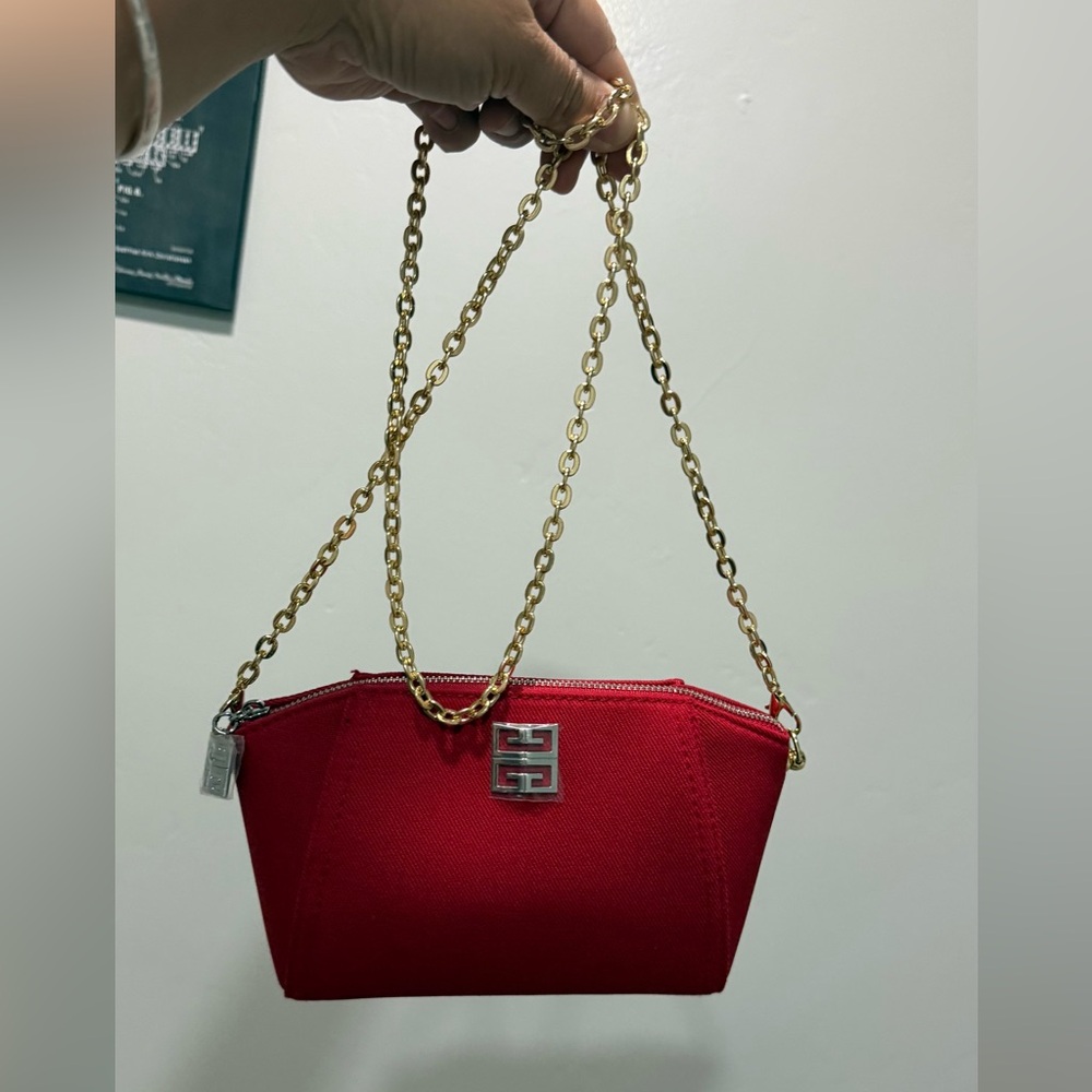 Givenchy Parfums red cosmetic clutch bag with a detachable gold chain strap.